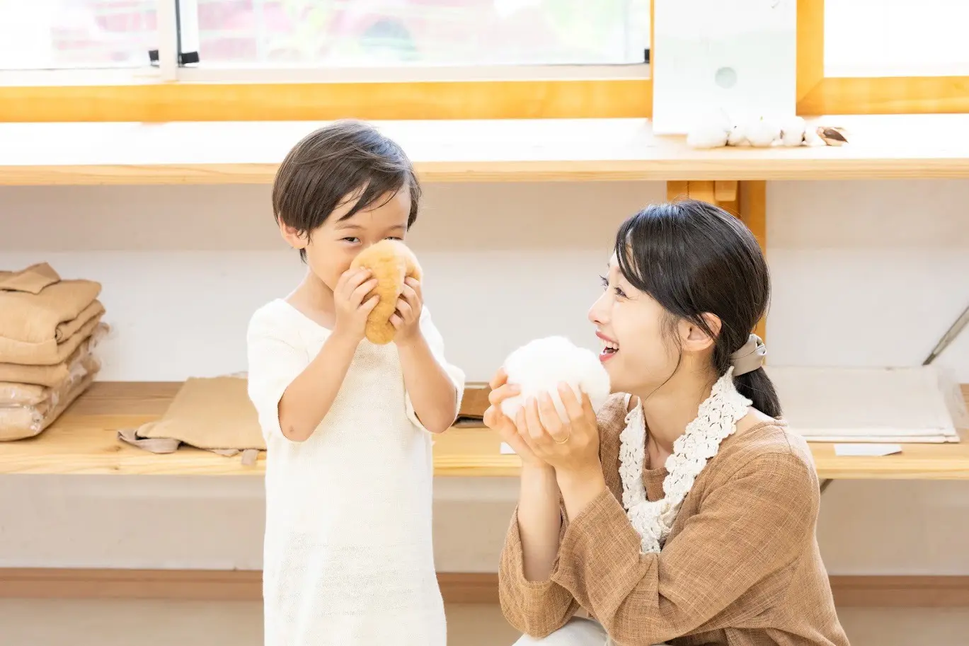 コットンボールを手に持って体験する親子の画像